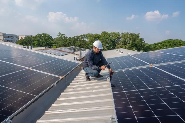 Painéis solares instalados na cobertura de um edifício ao pôr do sol