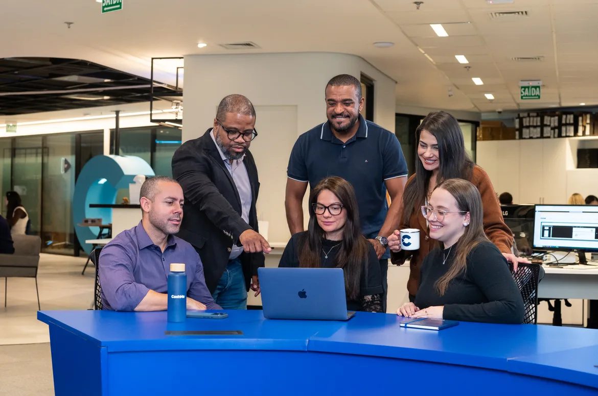 Time da CashMe reunido em uma área de convivência do escritório