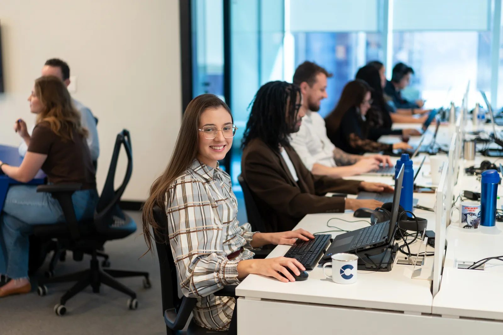 Equipe da CashMe trabalhando em suas estações no escritório