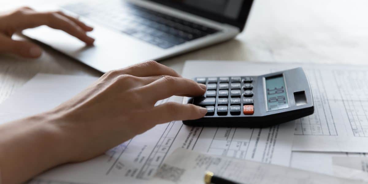 mulher fazendo cálculos na calculadora