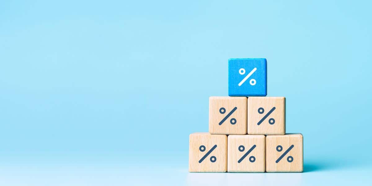 Com um fundo azul claro, há seis blocos de madeira empilhados, formando uma pirâmide. O último bloco, acima de todos, está destacado em azul.